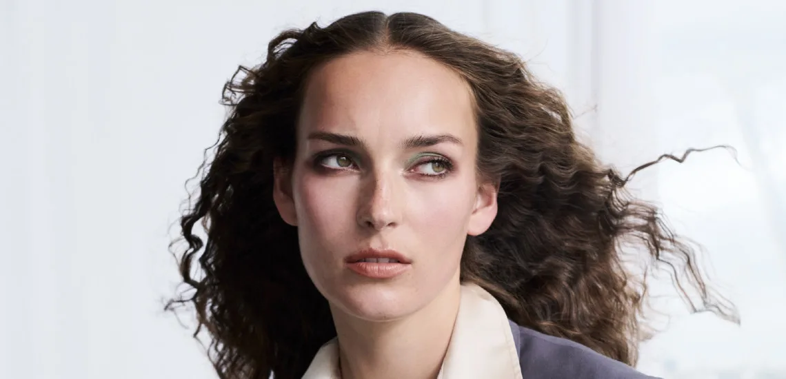 Portrait cheveux bouclés bruns au naturel, maquillage vert émeraude, collection Futuristic Ease La Biosthétique