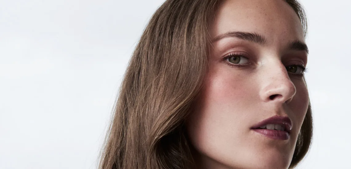 Gros plan profil, cheveux châtain lisses mi-longs au naturel, maquillage nude, beauté essentielle La Biosthétique